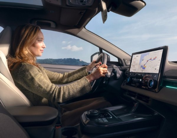Woman driving a car with a digital navigation screen.