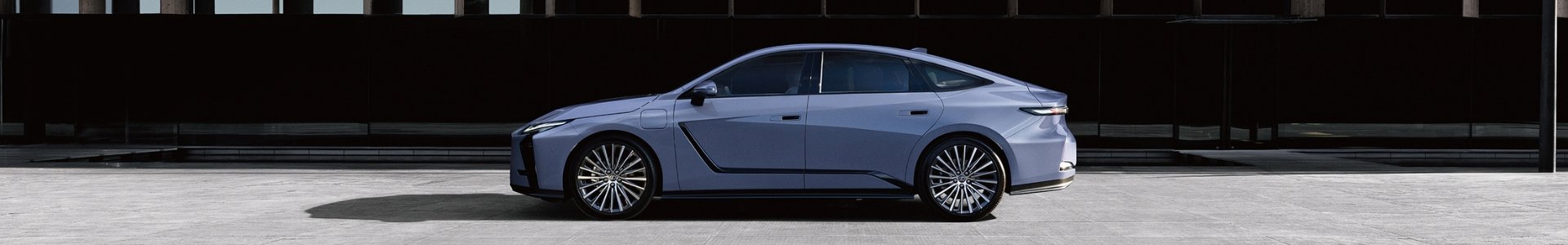 Side view of a blue sedan car parked on a pavement.