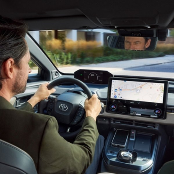 Man driving a Toyota car with a navigation system on the dashboard.
