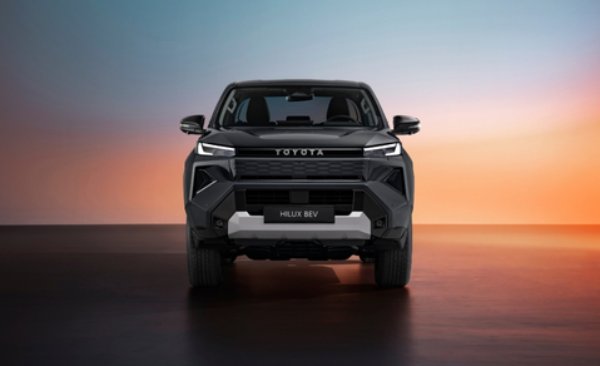 Front view of a black Toyota Hilux BEV against a gradient sky backdrop.