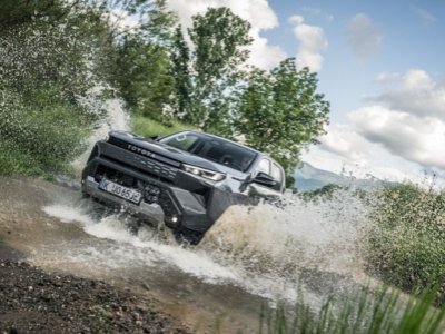 Toyota pick-up driving through water with a splash.