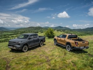 Two Toyota pickup trucks parked on a grassy hill.