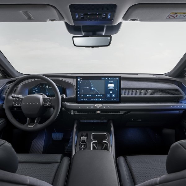 Car interior with steering wheel and digital display screen.