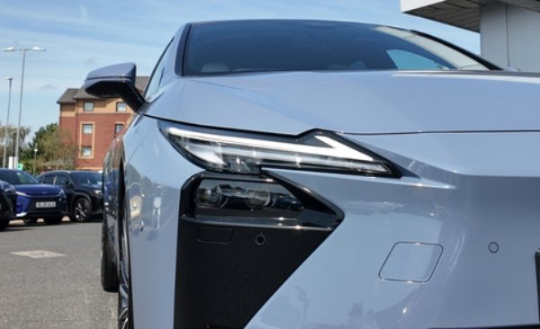 Silver car front view with sleek headlights and side mirror visible.