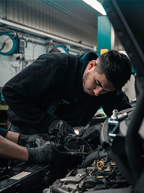 Mechanic in vehicle bonnet