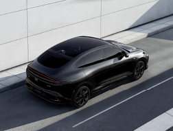 Sleek black car with a coupe-style design parked on a street.