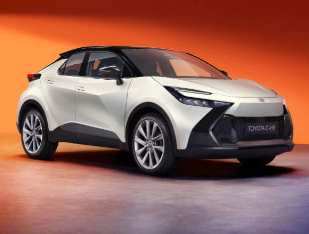 White Toyota CH-R, side view, with angular design and prominent front grille.