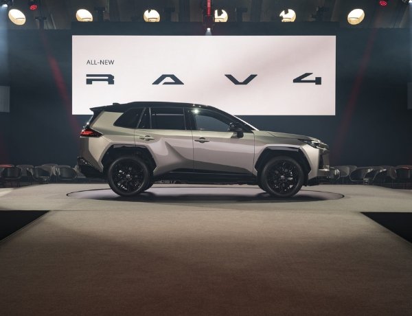 Side view of a silver SUV on display with a RAV4 sign above.