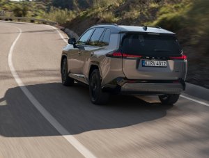 SUV driving on a winding road, rear view.
