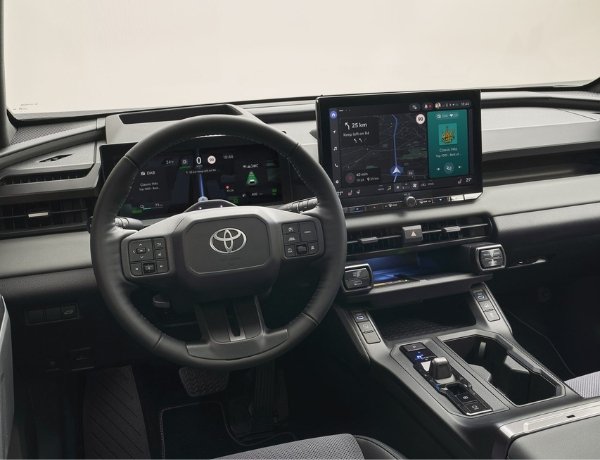 Toyota car dashboard with steering wheel and digital displays showing navigation and controls.