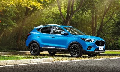 Blue SUV parked near trees with sunlight filtering through branches.