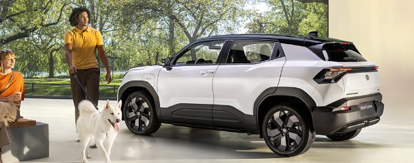 A white SUV parked indoors, a person walking a dog, and another sitting on a bench nearby.