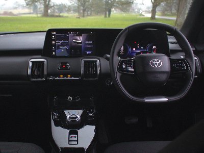 Interior view of a car with a touchscreen display and steering wheel featuring Toyota logo.