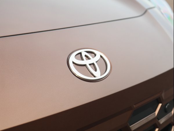 Close-up of the Toyota logo on a bronze car bonnet.