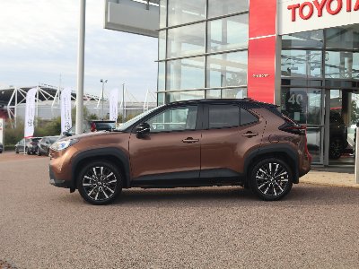 Brown Toyota SUV parked outside a glass-walled dealership.
